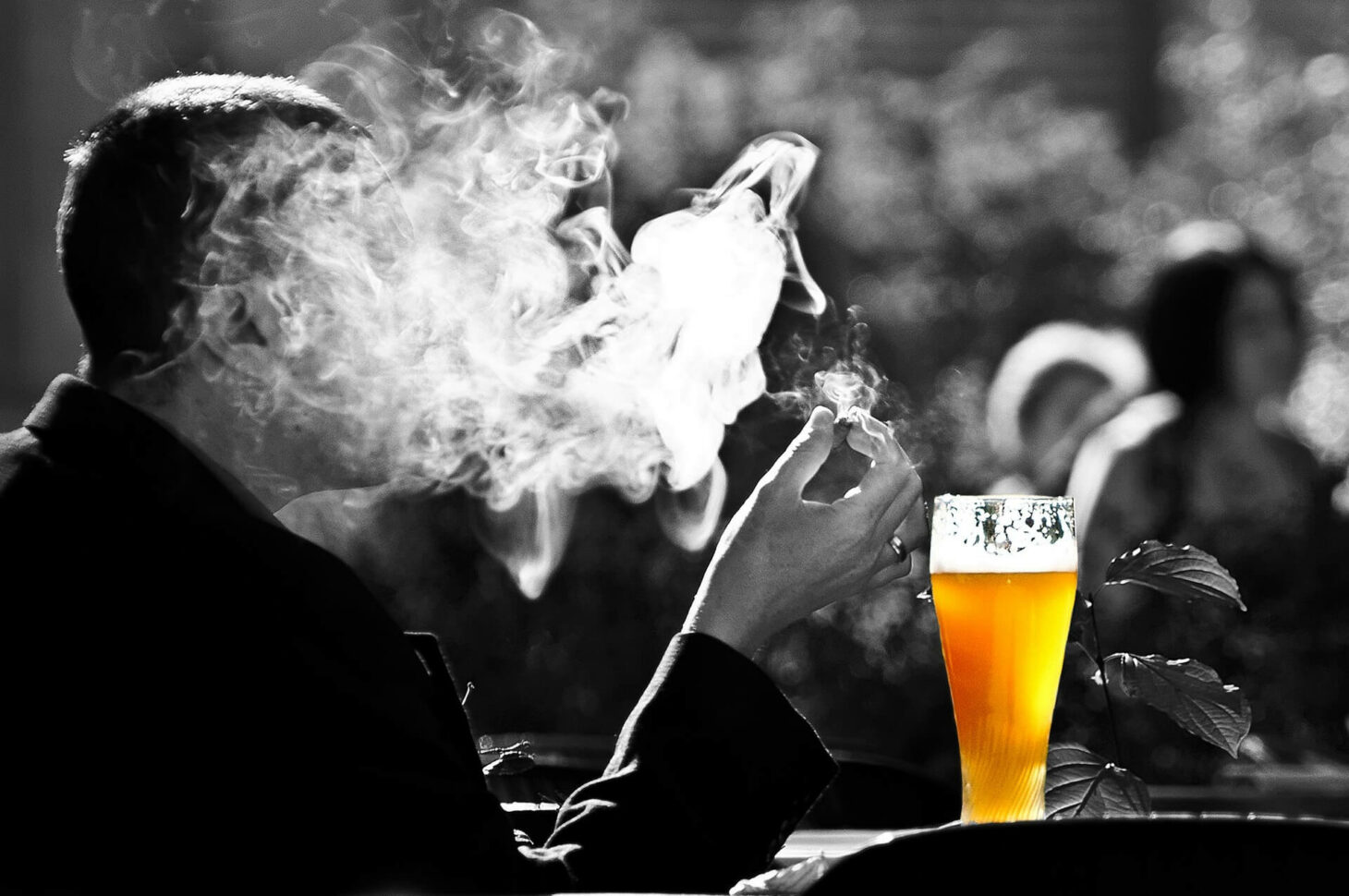Ein Mann raucht und trinkt Bier